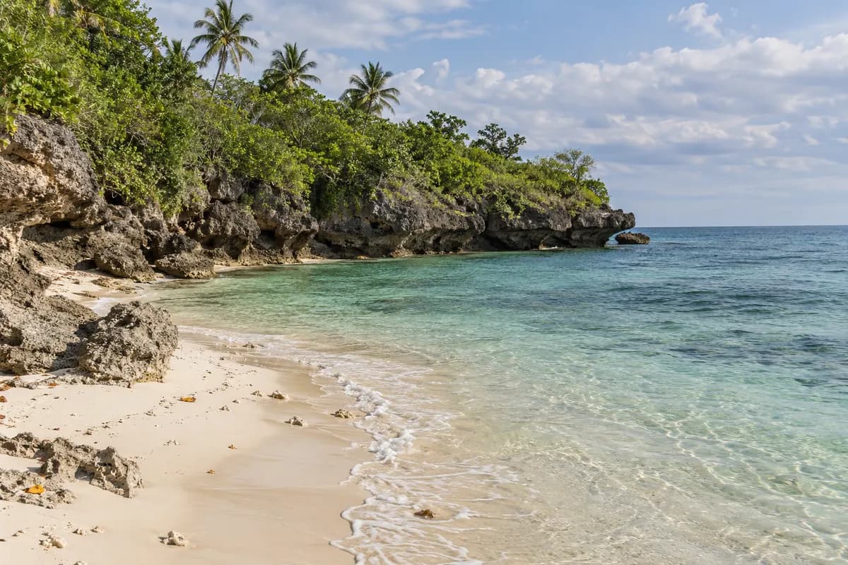 A quiet white-sand cove between limestone rocks in Anda, Bohol